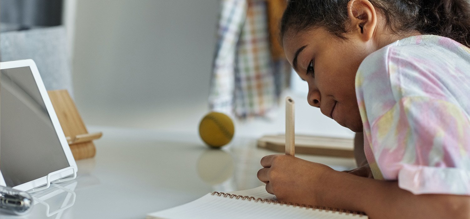 close up of young person writing in notepad