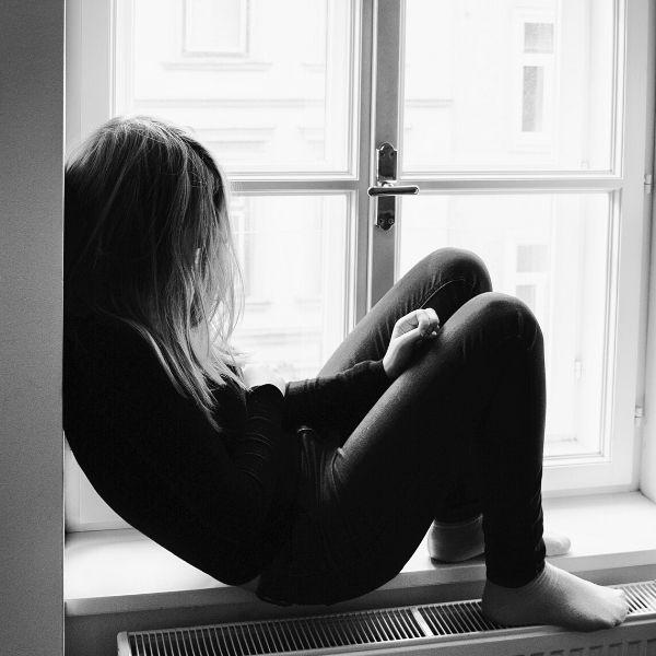 young person sitting on windowsill