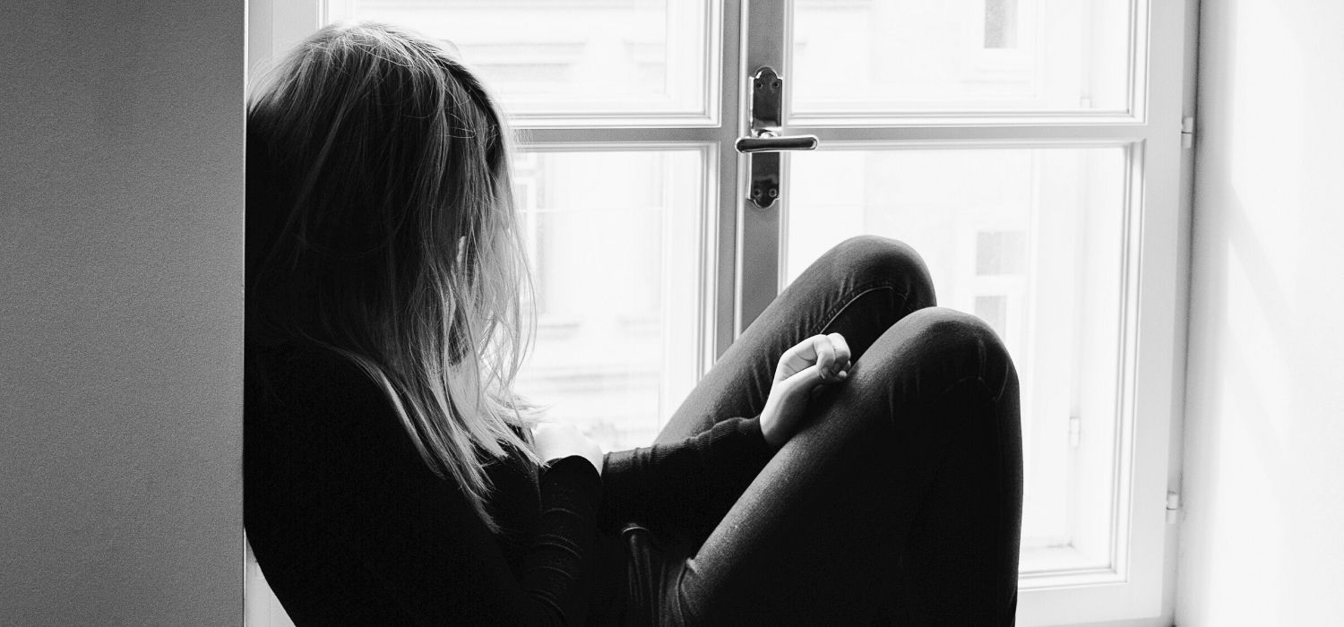 young person sitting by a window